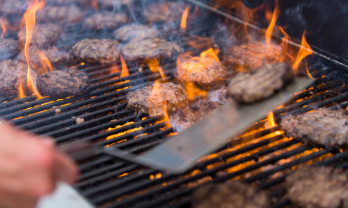 Burgers being cooked on a propane grill